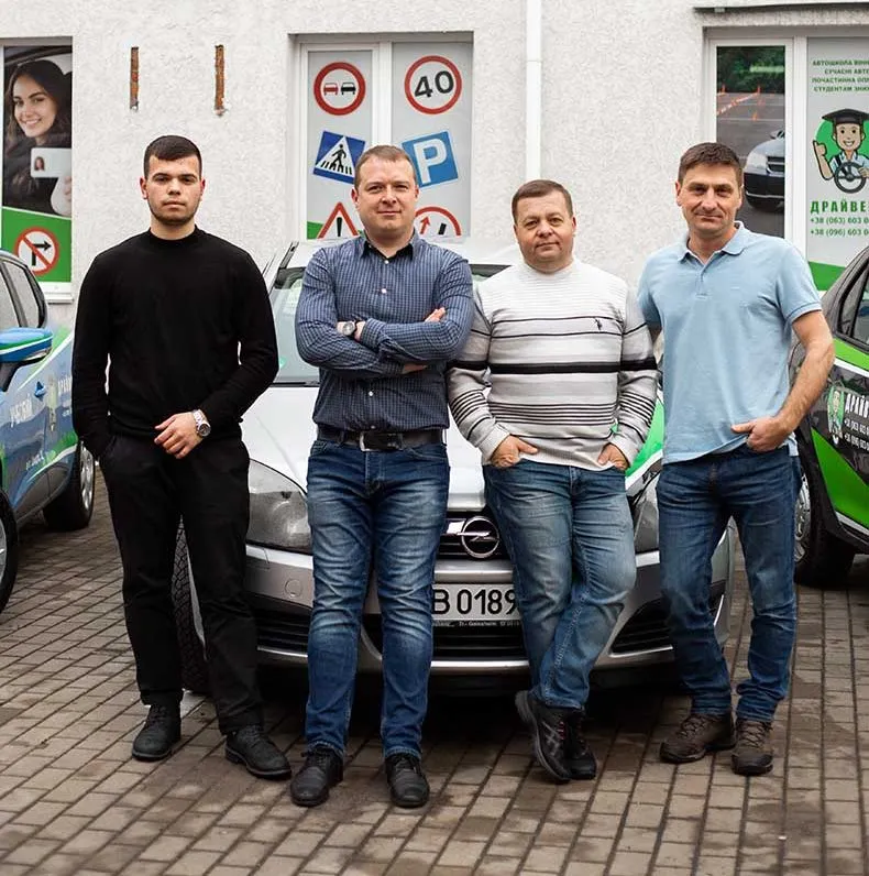 Команда інструкторів автошколи Драйвер+ біля навчального автомобіля — 4 досвідчених викладача
