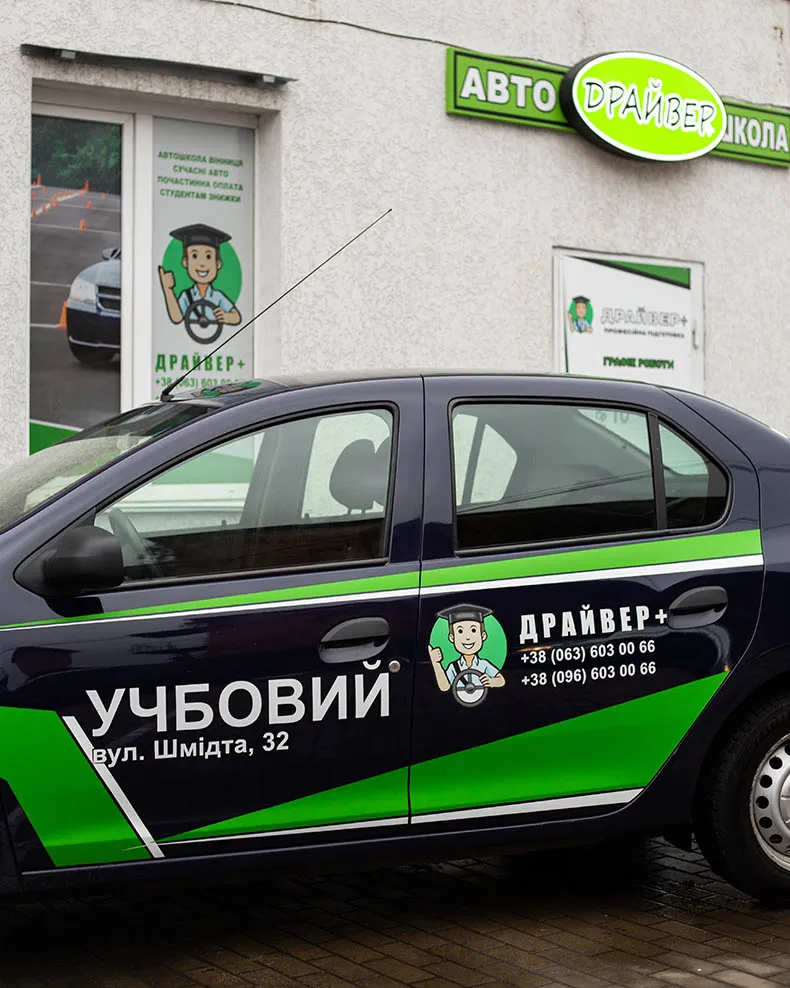 Темно-синий учебный автомобиль возле здания автошколы